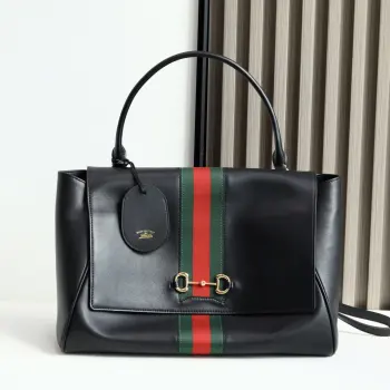 Generation Gucci系列深入探索品牌的典藏元素 将不同年代的设计融合成一种美学叙事 这款手提包采用顶部手柄设计 以柔软皮革打造 向品牌标志性的Horsebit和Web致敬 黑色软皮黑色皮革滚边金色调配件黑色帆布衬里 饰Diamante图案Horsebit 网状结构和皮革标牌 带有 Made in Italy Gucci 标志内部 1个拉链口袋手挽垂直长度 18 - 24.5厘米可拆卸和可调节皮革肩带长度 51 - 55cm按扣磁扣开合型号 875019 尺寸 37厘米 宽 x 29厘米 高 x 13厘米 深 重量 约825克颜色 黑色/全皮 意大利创作