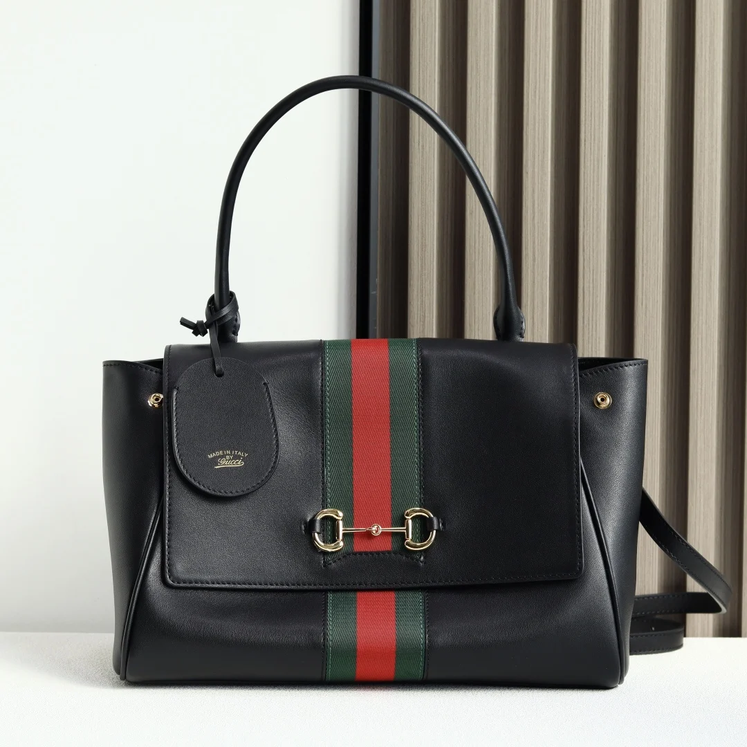 Generation Gucci系列深入探索品牌的典藏元素 将不同年代的设计融合成一种美学叙事 这款手提包采用顶部手柄设计 以柔软皮革打造 向品牌标志性的Horsebit和Web致敬 黑色软皮黑色皮革滚边金色调配件黑色帆布衬里 饰Diamante图案Horsebit 网状结构和皮革标牌 带有 Made in Italy Gucci 标志内部 1个拉链口袋手挽垂直长度 17厘米可拆卸和可调节皮革肩带长度 42 - 54厘米 长度 93 - 112厘米按扣磁扣开合型号 875018