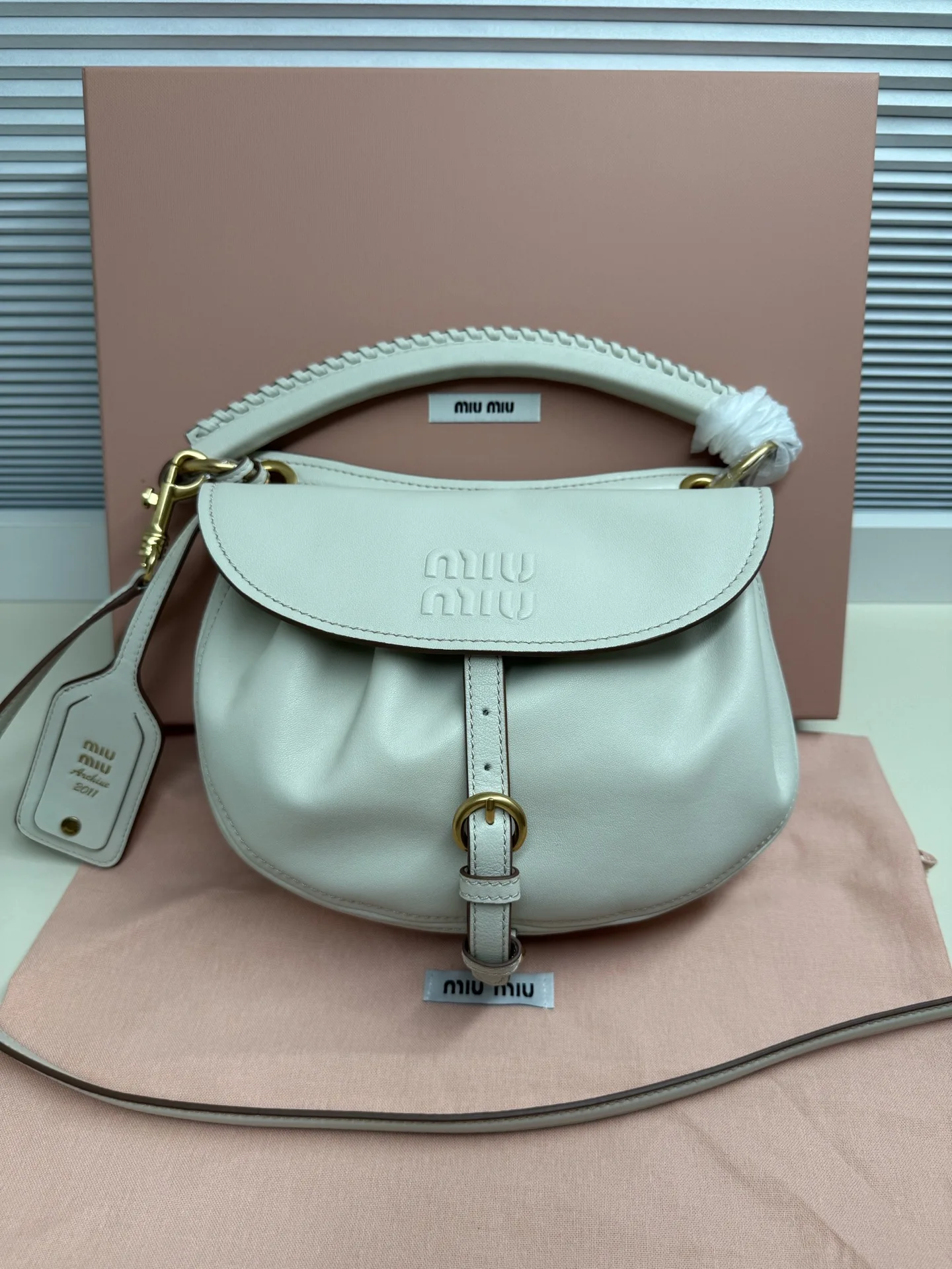原单MIUMIU女包|高仿MIUMIU女包|精仿MIUMIU女包|一比一MIUMIU女包型号:5BC221 橡木色材质:进口羊皮植揉Rendez-vous手袋曾亮相时装秀 灵感源自2011年档案款式 采用柔软皮革打造 以宽敞的水桶造型脱颖而出编织皮革手柄与复古格调细节相得益彰 提升日常实用性  皮革提手 饰以编织细节可拆卸可调节皮革肩带   可拆卸皮革名牌标签 复古金色五金配件翻盖式开合 配肩带 搭扣和钮扣绒面皮革内里 配贴袋压花字母徽标宽度 26厘米 高度 19厘米 长度 8厘米
