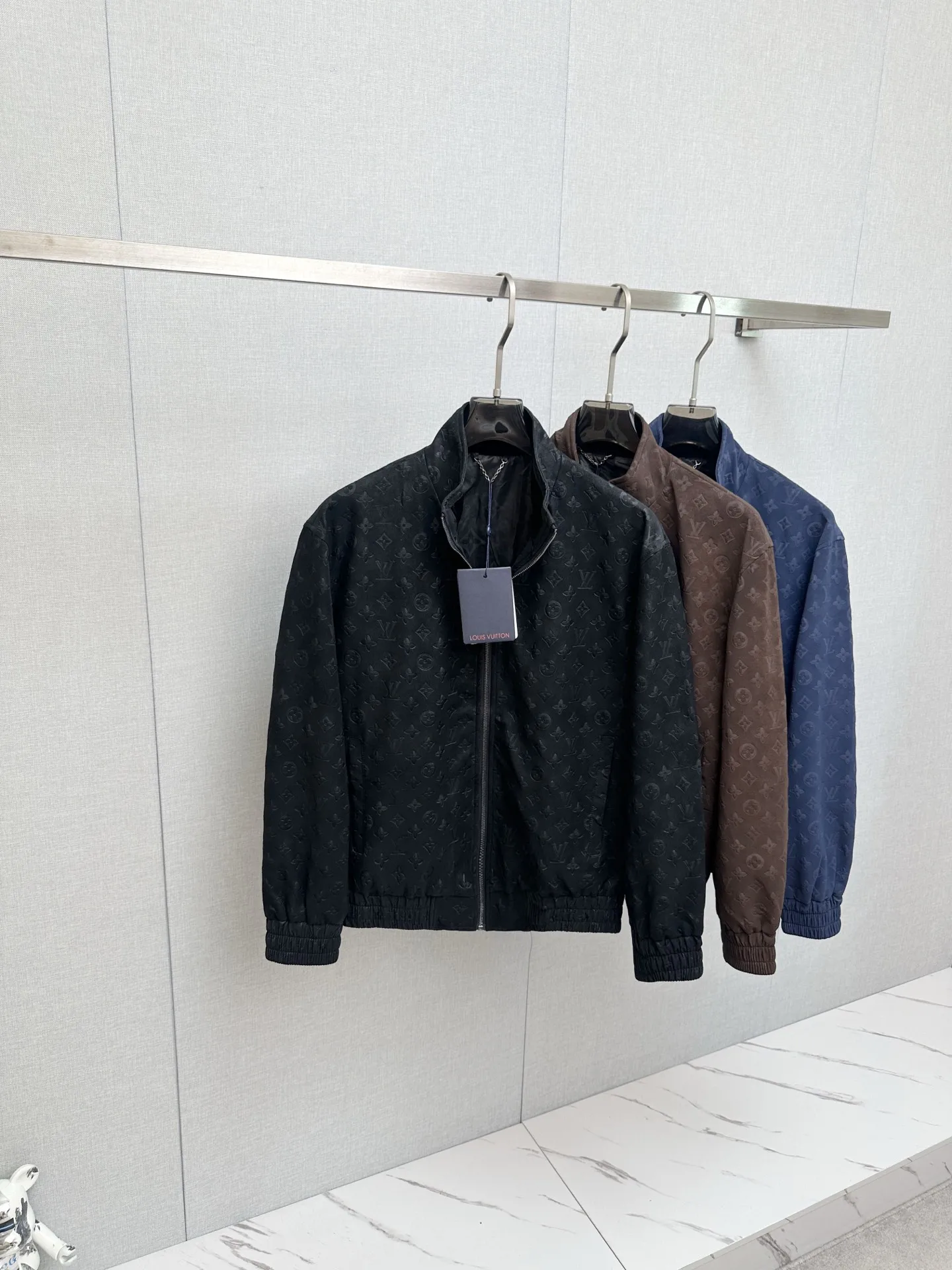 原单外套男装|高仿外套男装|精仿外套男装|一比一外套男装1V/路易 FW26 Monogram老花满印麂皮压花立领夹克外套面料采用定制麂皮质感面料 哑光高级雾面色泽 通体满幅LV老花立体压花 独立模具压制 花纹深浅 间距 排布严格对标原版 压印力度把控到位 不会出现压纹过浅模糊 压穿面料的问题 从面料染色 压花工艺 车位缝制到辅料定制 全程对标原版工序 统一对色校准色调 Size S-2XL