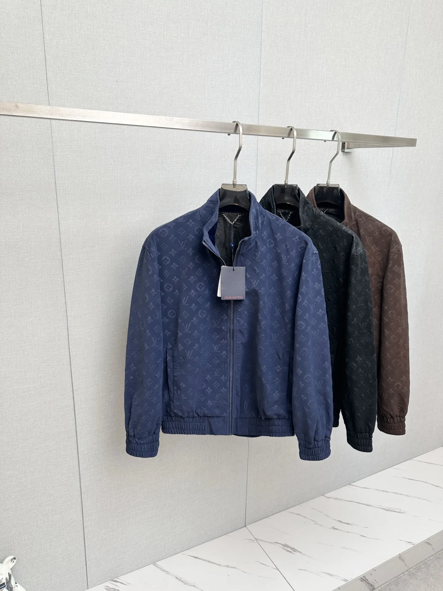 原单外套男装|高仿外套男装|精仿外套男装|一比一外套男装1V/路易 FW26 Monogram老花满印麂皮压花立领夹克外套面料采用定制麂皮质感面料 哑光高级雾面色泽 通体满幅LV老花立体压花 独立模具压制 花纹深浅 间距 排布严格对标原版 压印力度把控到位 不会出现压纹过浅模糊 压穿面料的问题 从面料染色 压花工艺 车位缝制到辅料定制 全程对标原版工序 统一对色校准色调 Size S-2XL