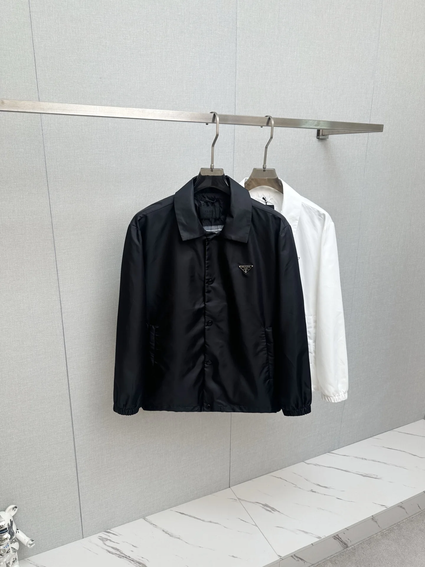 原单外套男装|高仿外套男装|精仿外套男装|一比一外套男装Prada 普拉达 26ss时尚翻领夹克.ZG同步.贸易公司渠道臻品 在面料选取和工艺方面都相当考究 极符合该品牌百年美学基调 低调且奢华 优雅且高贵 每一个细节都在力证品牌自身的高级感 通体将意式的极简 干练和户外功能性风格极致诠释 亦庄亦谐 上身型款十足 集时装感与设计感的一款宝藏级功能型装备 塑造出别具一格的造型单品 改良式的飞行员造型设计 颜色 黑色码数 S-2XL 46-54码 