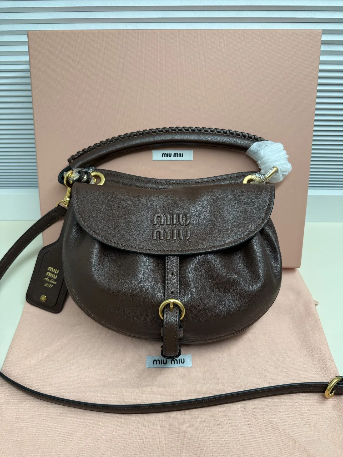 原单MIUMIU女包|高仿MIUMIU女包|精仿MIUMIU女包|一比一MIUMIU女包型号:5BC221 材质:进口羊皮植揉Rendez-vous手袋曾亮相时装秀 灵感源自2011年档案款式 采用柔软皮革打造 以宽敞的水桶造型脱颖而出编织皮革手柄与复古格调细节相得益彰 提升日常实用性  皮革提手 饰以编织细节可拆卸可调节皮革肩带   可拆卸皮革名牌标签 复古金色五金配件翻盖式开合 配肩带 搭扣和钮扣绒面皮革内里 配贴袋压花字母徽标宽度 26厘米 高度 19厘米 长度 8厘米