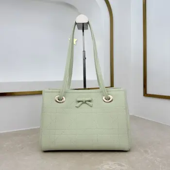  编号 M1410 淡绿色蝴蝶结这款购物袋由乔纳森 安德森 (Jonathan Anderson) 为 Dior 倾情打造 实用宽敞的设计饰以精美蝴蝶结提升格调 展现 Dior 的全新标志细节 小号款式 牛皮和皮革装饰等材质巧妙结合 柔软廓形和巧妙的滑动式顶部手柄别具一格 可手提 肩背或斜挎 主体 牛皮革 棉 科技面料里料 棉 亚麻 牛皮革磁性开合正面饰以 Dior 标志皮革蝴蝶结顶部滑动式皮革手柄 搭配 CD 标志孔眼内部拉链口袋内部插袋编号: M1410尺寸 27 x 19 x 13.5 厘米 长 x 高 x 宽 