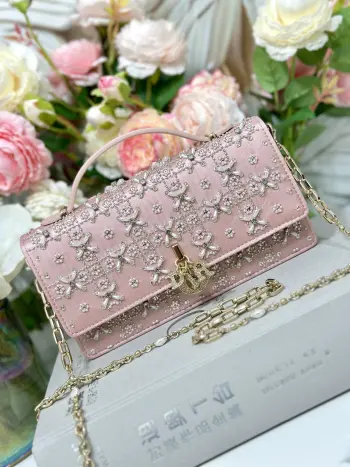 Miss Dior 刺绣粉色珠钻吊饰钻扣 链条包系列的新品 优雅实用 采用缎面精心制作 饰以流星缉面线 翻盖点缀以 D.I.O.R. 吊饰 两个隔层和拉链手拿包可收纳各种日常用品 可与日常或晚装造型搭配 经典的顶部手柄设计 搭配可拆卸链条肩带 可手提 肩背或斜挎 尺寸 21 x 11.5 x 4 厘米 型号M0997