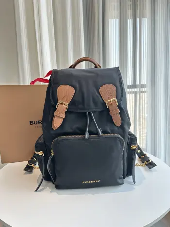 特级  黑配棕  The Rucksack 军旅背包 为时装秀主打配饰 款式轻便且防雨 肩背带采用舒适的加垫设计 背包以标志性 Bur Trench 风衣的独创面料作为灵感来源 采用与棉质嘎巴甸同为密织结构的柔韧尼龙材质制成 其柔软休闲的包型可追溯至 20 世纪初期历史档案中的军旅风格 在此基础之上又添加了多个功能性拉链口袋 28 x 15 x 42cm