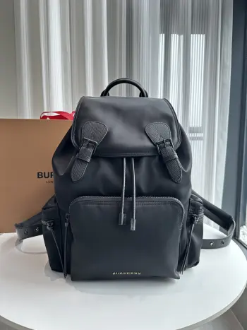 特级  兰配黑扣  The Rucksack 军旅背包 为时装秀主打配饰 款式轻便且防雨 肩背带采用舒适的加垫设计 背包以标志性 Burberry Trench 风衣的独创面料作为灵感来源 采用与棉质嘎巴甸同为密织结构的柔韧尼龙材质制成 其柔软休闲的包型可追溯至 20 世纪初期历史档案中的军旅风格 在此基础之上又添加了多个功能性拉链口袋 28 x 15 x 42cm
