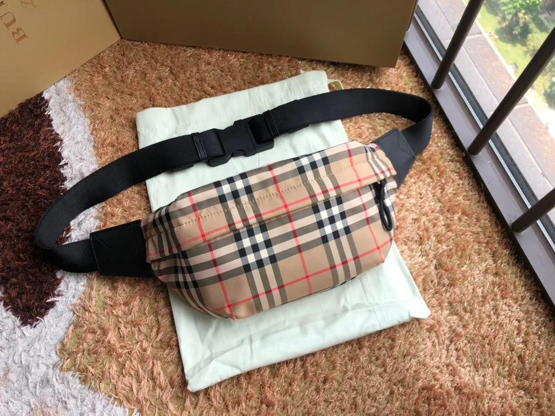 B家顶级原单腰包借鉴九十年代街头风格 选用 Vintage 复古格纹接合棉打造 装饰提花精纺品牌徽标 搭配精美皮革边饰 可用背带斜挎或系于腰部 型号:0607腰包尺寸:31 x 7.5 x 16cm
