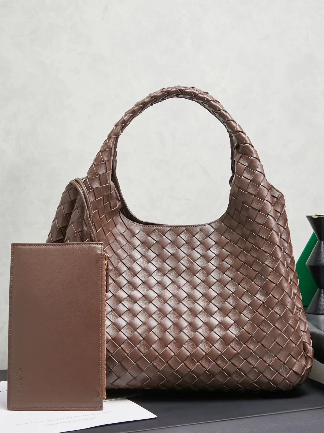 原单BV女包|高仿BV女包|精仿BV女包|一比一BV女包BOTTEGA VENETA葆蝶家2025新品Campana肩背包上市啦~首先夸夸这款包包的自重，作为一款不算很小的包包，它非常的轻便日常，对于我这种出门需要携带很多随身物品的人来说这个优点真是太棒了，很大程度减轻了出行的负担️在造型上有点像是parachute和jodie的结合体，钝钝的三角造型可爱憨厚，背出门逛街就是心情好的加速器，提手和包身都是经典编织，在原本的敞口设计上加了系带，如果没有系起来，包包拎起来就会有小菜篮的造型哦款号：844250 尺寸：39*24*18.5cm