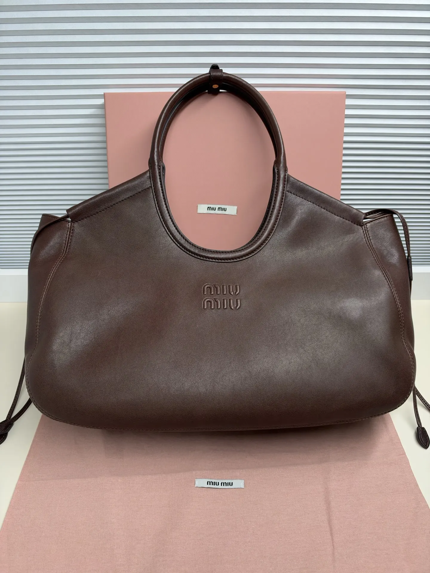 原单MIUMIU女包|高仿MIUMIU女包|精仿MIUMIU女包|一比一MIUMIU女包托特包 标志性lvy融合当代设计,柔软宽敞的购物包廓形,以Nappa皮革的岁月质感呈现,沉稳又内敛,搭配徽标与侧面抽绳等精致细节,尽显格调,可单肩可斜挎,实用性和颜值又在线,通勤、逛街、约会都适配,低调显贵,耐看又有品味40-30-15cm5BG342