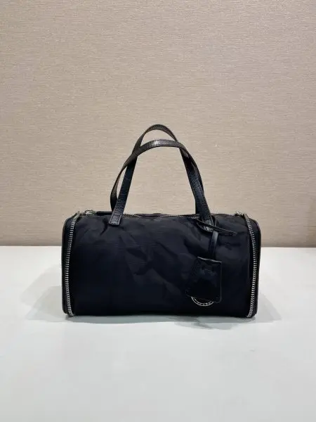 新品收纳包1TT348平纹2026秋冬系列时装秀中的层次造型,同样延伸至个性独特的皮具设计。这款迷你包采用创新可折叠廓形,以旅行袋造型呈现,随日常节奏自由变换。标志性Re-Nylon(再生尼龙)与小牛皮相结合,映射这款配饰的多元特质,于优雅与当代实用之间呈现平衡之美。长10x高11.5cm