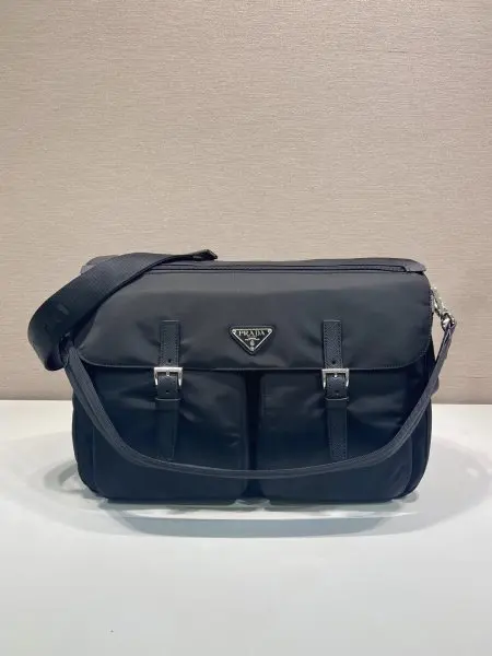 新品邮差包2VD072这款邮差包配饰兼具实用功能与美观设计,造型时尚现代。它由Re-Nylon材料制成,通过简洁的线条与精致的技术细节展现出独特的都市风格。多个口袋以及独特的装饰元素进一步增强了其动感十足的特性,可拆卸的加垫尼龙带手柄,可调节的编织尼龙带肩带。翻盖与拉链闭合,容量空间大,长39x高26x底18cm